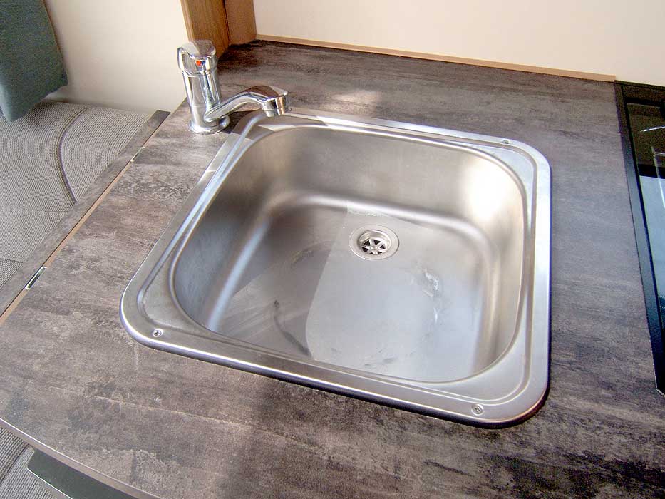The recessed stainless steel kitchen sink with single mixer tap. It can be folded away when not needed.